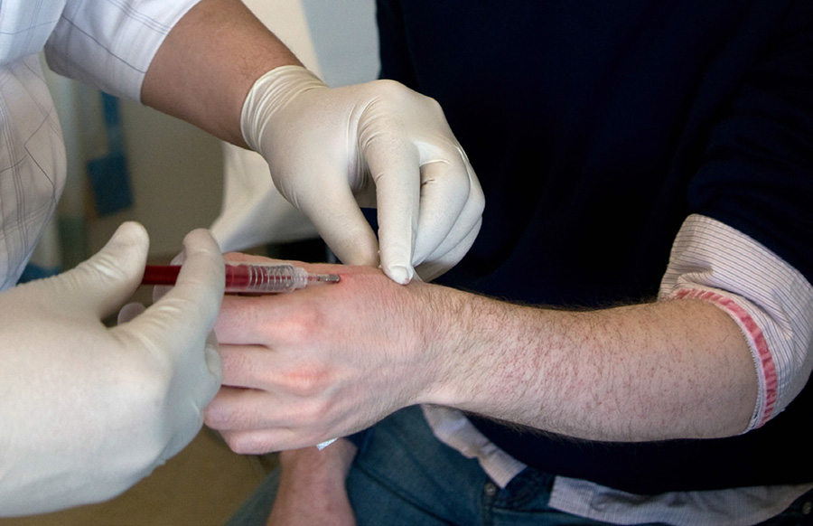 A doctor implants an RFID chip into the hand of a researcher